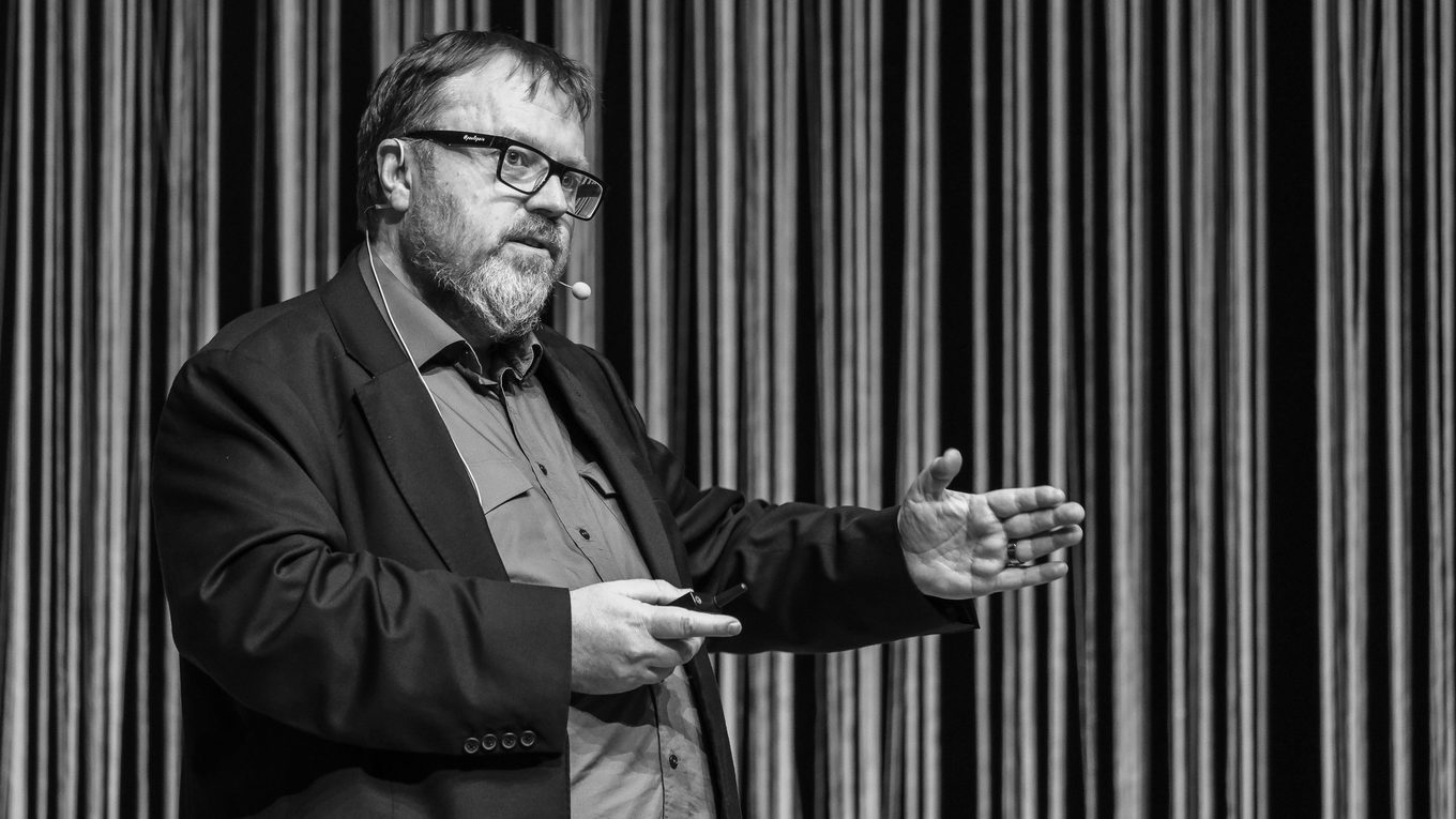Paul Spain speaking on stage at a conference